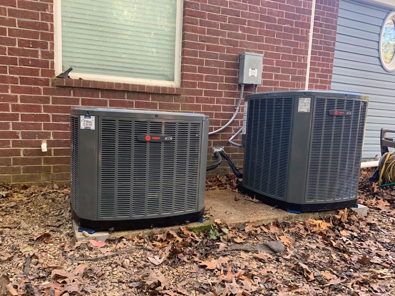 Air conditioner condensers beside a brick home in Arlington