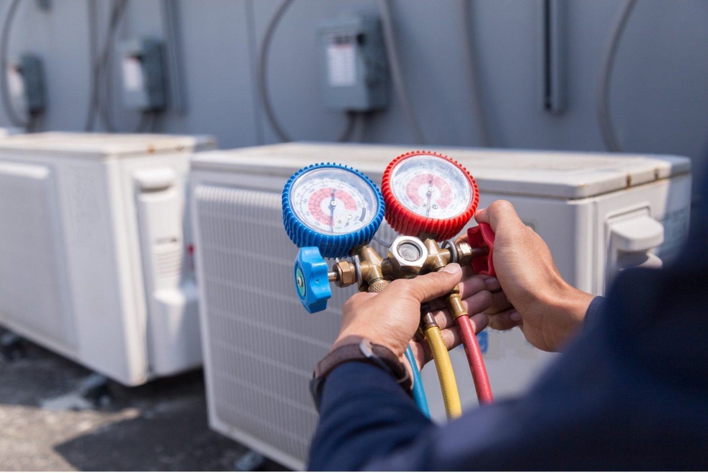 Manifold gauges in a technician's hands during a service call